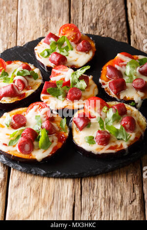 Pizza aus gebackene Auberginen mit Mozzarella, Tomaten, Wurst und grünen Close-up auf dem Tisch. Vertikale Stockfoto