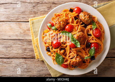 Hausgemachte Frikadellen mit Spaghetti, Auberginen und Tomaten close-up auf einem Teller. horizontal oben Ansicht von oben Stockfoto
