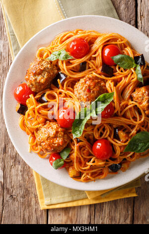 Spaghetti mit Fleischbällchen, Gemüse in Tomatensauce close-up auf einem Teller auf dem Tisch. Vertikal oben Ansicht von oben, rustikalen Stil Stockfoto
