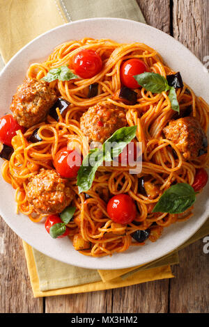 Köstliche traditionelle Pasta Spaghetti mit Fleischbällchen, Auberginen in Tomatensauce close-up auf einem Teller auf dem Tisch. Vertikal oben Ansicht von oben Stockfoto