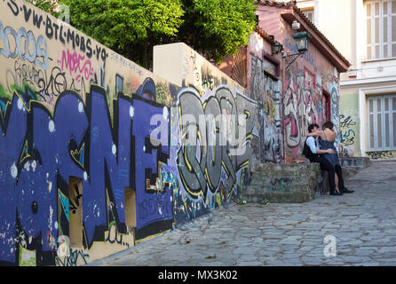 Paare, die in einer Seitenstraße mit Graffiti in der Plaka Viertel von Athen, Griechenland Stockfoto