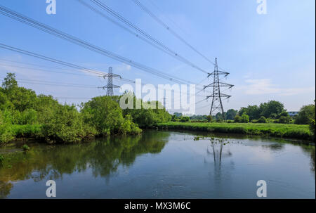 Strommasten im Fluss Test in der Nähe seiner Mündung in den unteren Test Nature Reserve, Totton, Redbridge, Southampton, Hampshire, UK wider Stockfoto