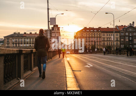 Prag, 23. September 2017: Leute gehen oder einen Spaziergang auf der Brücke bei Sonnenuntergang. Traditionelle tschechische Architektur Stockfoto