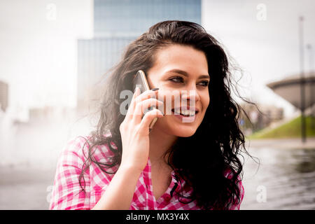 Attraktive spontane Frau am Telefon zu sprechen. Authentizität und Spontaneität. Authentische Gespräch über das Telefon. Stockfoto