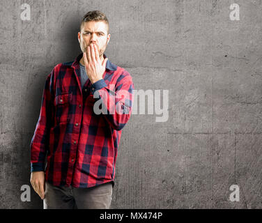 Jungen gutaussehenden Mann deckt Mund in Schock, blickt schüchtern, Stille und Fehler Konzepte, Angst Stockfoto