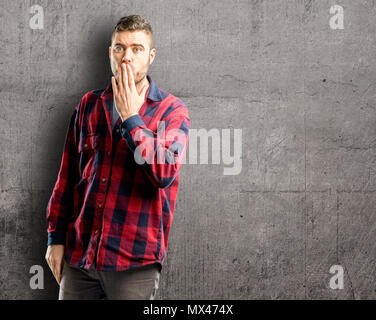 Jungen gutaussehenden Mann deckt Mund in Schock, blickt schüchtern, Stille und Fehler Konzepte, Angst Stockfoto