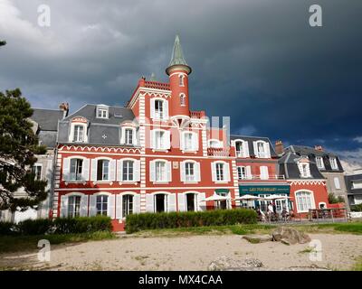 Menschen, die noch auf der vorderen Terrasse wie Gewitterwolken Rahmen der lokalen Landmark Hotel und Restaurant, Les Tourelles, Le Crotoy, Frankreich Stockfoto