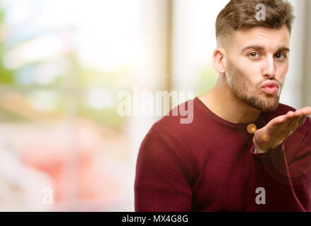 Hübscher junger Mann Liebe auszudrücken, Schläge Kuss auf Kamera, flirten Stockfoto