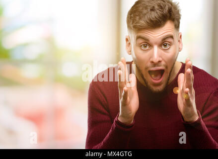 Hübscher junger Mann Stress die Hände auf den Kopf, Panik, Angst, schreien Stockfoto