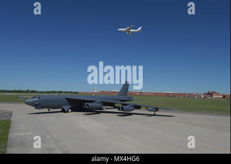 Boeing B-52 H, 60-0005, posiert vor der Oklahoma City Air Logistics komplexe Gebäude. 3001 folgende Generalüberholung während einer Boeing E-6B TACAMO Flugzeuge overhead am 1. Mai 2017 fliegt, Tinker Air Force Base, Oklahoma. OC-ALC ist verantwortlich für das Depot auf Ebene der Wartung der beiden Flotten mit einem großen Teil der Arbeit, die in der Gebäude hinter dargestellt. Stockfoto