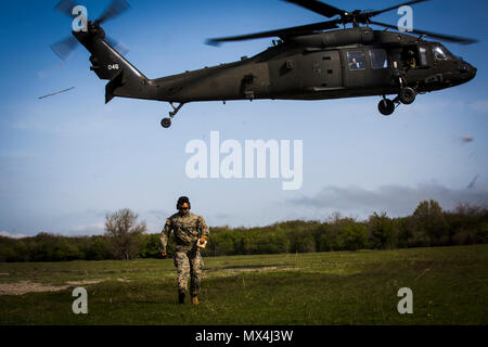 US Marine Sgt. Viktor Cadiente, ein vorwärts Beobachter mit Schwarzmeer Rotations Kraft 17.1, ruft in der Landung der US-Armee UH-60 Blackhawk Hubschrauber während Übung Platinum Eagle 17,2 am Babadag Trainingsbereich, Rumänien, 30. April 2017. Marines mit BSRF und Marine Rotations Kraft Europe 17.1 hielt eine Klasse mit montenegrinische Soldaten über Landung Hubschrauber für Unfall Evakuierungen auf Fähigkeiten und Interoperabilität zu verbessern. Partnerschaften von multinationalen Übungen wie diese gebildet, und an militärischer Ausbildung Engagements sind wichtig im Umgang mit Regionalausgaben und halten Frieden ich Stockfoto