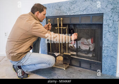 Junger Mann von innen Home Interior Kamin mit maschensieb sitzen, alten Retro Vintage golden gold Instrumente Werkzeuge oder Zubehör wie staubig Sh Stockfoto