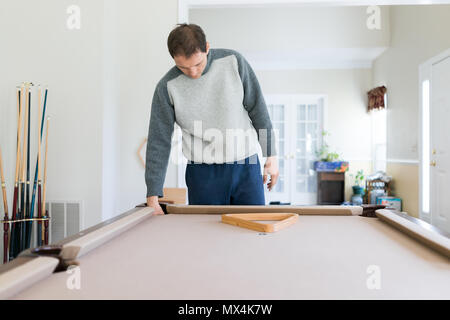 Innen im Haus Haus mit Pool Billard Tisch im Wohnzimmer, junger Mann im kalten Winter Pullover einrichten Spiel, Dreieck Rack Stockfoto