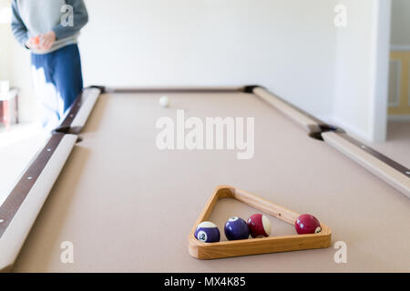 Innen im Haus Haus mit Billard Billardtisch Nahaufnahme von Dreieck in Wohnzimmer, junger Mann im kalten Winter Pullover sie Kugeln, die Einrichtung von gam Stockfoto