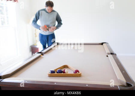 Innenbereich Haus mit Billard Billardtisch Nahaufnahme von Dreieck Zahnstange Wohnzimmer, junger Mann im kalten Winter Pullover sie Kugeln, die Einrichtung von g Stockfoto