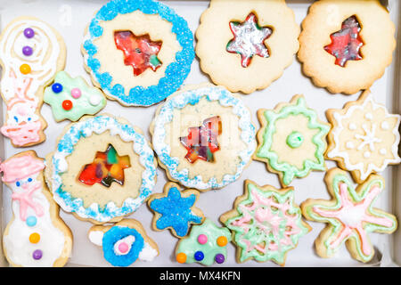 Fach Papier Verpackung gefüllt mit vielen eingerichteten Zuckerglasur glasiert mit Kandiszucker bunte künstlichen blauen Streuseln Weihnachten gebacken hausgemachte cooki Stockfoto