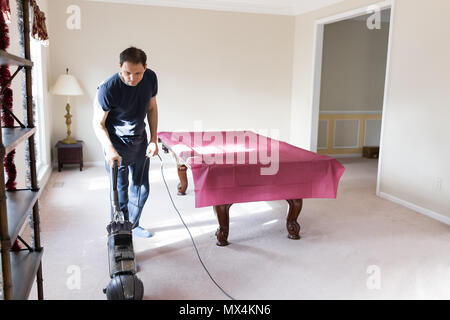 Junger Mann Haus Mann bleiben zu Hause Vati Staubsaugen mit Vakuum auf dem Teppich boden, Innen, Innere des Haus Wohnzimmer Billard, das häusliche Leben Stockfoto