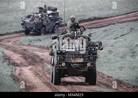 Ein Konvoi von Mobilität Weapon-Mounted Installation Kit" Schakale" mit der britischen Armee 1. Der Königin Dragoon Guards, sicher ein Bereich, während in einer Aufklärung Übung während Sabre Streik 18 mit Battle Group Polen Bemowo Piskie, Polen, 2. Juni 2018 beteiligt. Sabre Streik ist eine multinationale Übung derzeit in seinem achten Jahr. Die diesjährige Übung, die läuft von Juni 3-15, tests Verbündete und Partner aus 19 Ländern auf ihrer Fähigkeit, arbeiten zusammen, um die Aggression in der Region zu verhindern und die Fähigkeit der einzelnen Einheit ihre benannten Mission durchführen zu verbessern. (U.S. Armee Foto von Sp Stockfoto