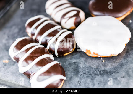 Schokolade braune und weiße Zuckerglasur Long John eclair Donuts closeup auf Bäckerei Fach, frittierter Vanille, lecker lecker Stockfoto