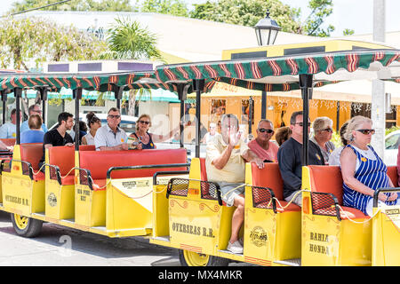 Key West, Vereinigte Staaten - 1. Mai 2018: Menschen reiten tour bus Trolley glücklich lächelnde winkende Hände, Gelb touristische Farbe in Florida Insel auf Reisen Stockfoto