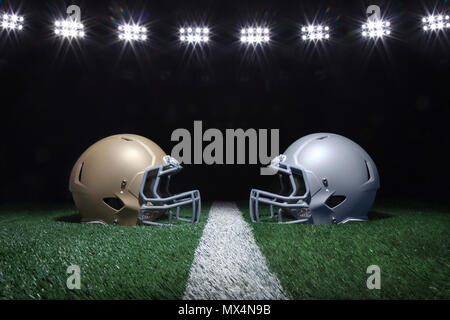 Gold und Silber Fußball Helme mit Blick auf ein Yard Linie unter Stadion Lichter in der Nacht Stockfoto