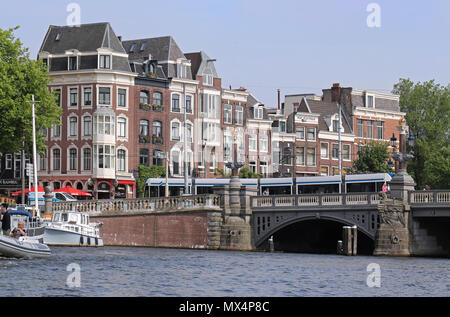 Stadtbild von Blauwburg Brücke mit Laterne Pole in Form von Kronen über die Amstel in Amsterdam mit der Straßenbahn über gehen Stockfoto