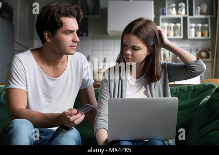 Wütend Mann holding Kreditkarte Schuld Frau von budgetüberschreitungen M Stockfoto