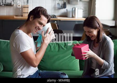 Paar den Austausch von Geschenken Eröffnung Boxen mit präsentiert auf der Uhr begeistert Stockfoto