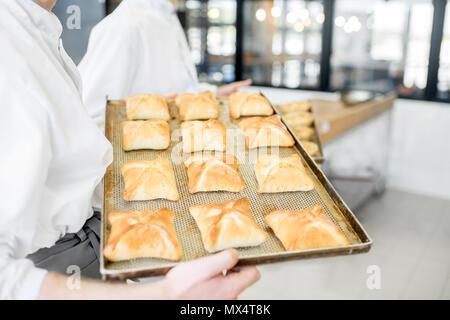 Halten Sie das Fach mit frisch gebackenen Brötchen Stockfoto