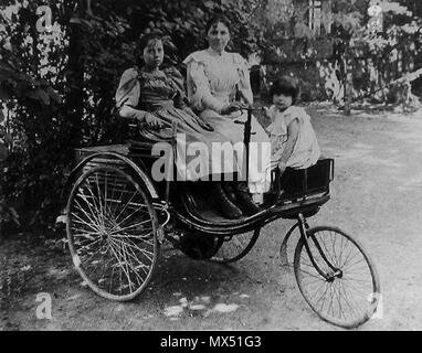 . English: Foto mit Thilde, Clara und Ellen Benz (von links) auf einem Patent-Motorwagen. Englisch: Foto mit Thilde, Clara und Ellen Benz sitzen auf einem Patent-Motorwagen. ca. 1900. Unbekannt 80 Benz-Patent-Motorwagen-mit-Thilde, - Clara-und-Ellen-Benz Stockfoto