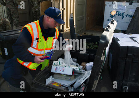 U.S. Coast Guard Marine Science Techniker Petty Officer 1st Class Gary Bullock prüft nicht angemeldete hazmat Materialien innerhalb einer Ladung vor dem Transport des Containers in Fort Polk, Louisiana aus der gemeinsamen Basis Elmendorf-Richardson, Alaska, 2. Mai 2017. Der 4. Brigade Combat Team (Airborne), 25 Infanterie Division wird eine Rotation um die Joint Readiness Training Center in Fort Polk. Bullock ist auf die Coast Guard Marine Sicherheit Loslösung Homer zugeordnet. Stockfoto