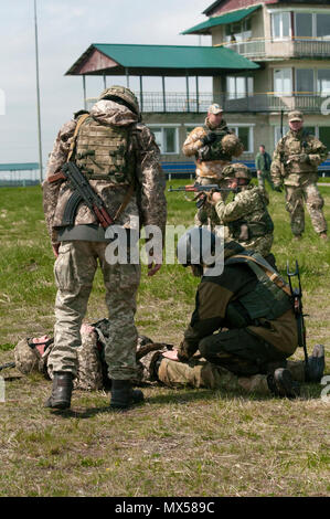 Ein Soldat aus dem 1 Airmobile Bataillon, 79 Air Assault Brigade gilt ein stauschlauch während des Kampfes Lebensretter Ausbildung an der Yavoriv CTC auf der internationalen Friedens und der Sicherheit in der Nähe von Yavoriv, Ukraine am 3. Mai 2017. CTC-Trainer, mit Soldaten der 45Th der US Army Infantry Brigade Combat Team zusammengeschlossen, sind Gebäude Professionalität innerhalb der Ukrainischen Militär durch strukturierte Ausbildung. Der 45 IBCT ist als Teil des Gemeinsamen multinationalen Ausbildung Group-Ukraine bereitgestellt und ist mit Kanadischen, britischen, polnischen, litauischen und Dänischen service Mitglieder gekoppelt. Die Mission von Stockfoto