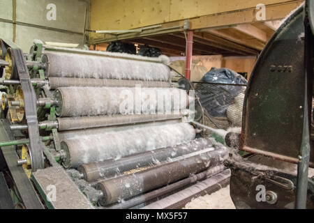 Wolle kardieren; Bürsten von Wolle mit Draht Zähne die Fasern auszurichten. Benutzerdefinierte Woollen Mills, Carstairs, Alberta. Stockfoto