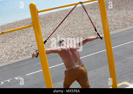 Ein Mann abgebildet mit Bewegung im Freien Ausrüstung am Strand in Chichester, West Sussex, UK. Stockfoto