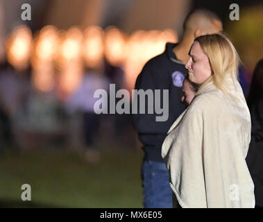 PARKLAND, FL - 16. Februar: Eine junge Frauen Orte Blumen an einer Gedenkstätte, ehrt die Opfer der Masse schießen auf Marjory Stoneman Douglas High School, At Pine Trail Park am 16. Februar in Parkland, Florida 2018. Polizei verhaftet 19-jährigen ehemaligen Schüler Nikolas Cruz für die Ermordung von 17 Personen an der High School. Personen: Atmosphäre Stockfoto