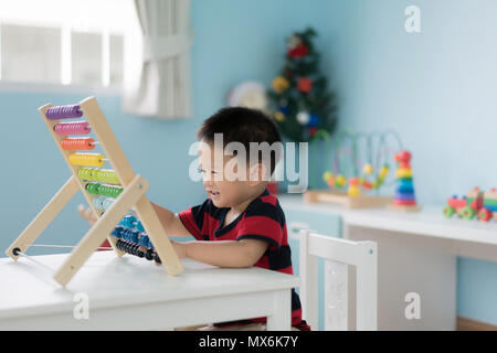 Asiatische Kleinkind baby boy lernt zu zählen. Niedliche Kind spielen mit Abacus Spielzeug. Little boy Spaß Zuhause zu Hause. Pädagogisches Konzept für Kleinkind bab Stockfoto