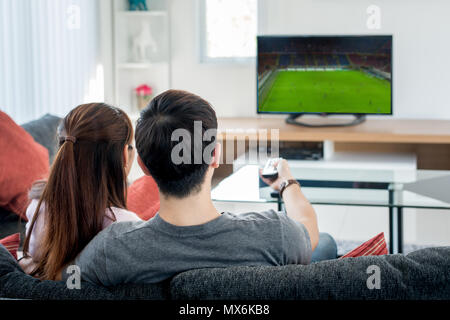 Ansicht der Rückseite des asiatischen Paar, Fußball im Fernsehen im Wohnzimmer. Fußball festival Konzept. Stockfoto
