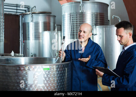 Positive Weingut Arbeitnehmer, die Noten während der Prüfung in Gärung Abschnitt Stockfoto