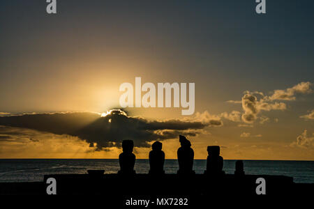 Dramatische bunte orange Sonnenuntergang und Sonneneinbruch mit Ahu Moai Silhouetten, Tahai, Osterinsel, Rapa Nui, Chile Stockfoto
