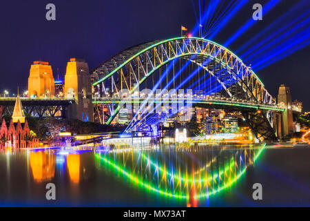 Blau hell strahlen von Laser unter arch der Sydney Harbour Bridge bei Vivid Sydney Light Show Festival mit Reflexion der Lichter. Stockfoto