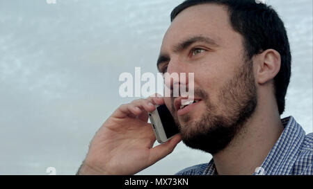 Glückliche Menschen am Telefon sprechen in Sunset Stadt. Professionelle Schuß auf BMCC RAW fith High Dynamic Range. Sie können es verwenden, z. B. in ihrem kommerziellen Video, Busines Stockfoto