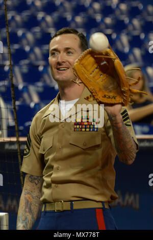 MIAMI, Fla.---- Staff Sgt. Jeremy R. Plympton hilft Konteradmiral Roy I. Kitchener warm up vor der Marlins versus Strahlen baseball spiel bei den Marlins Stadion Mai 2, 2017. Kitchener, dem Kommandeur der Expeditionary Strike Group 2, warf das Spiel öffnen Kugel als Teil der 27. jährlichen Flotte Woche Port Everglades. Whiston, einer von mehr als 100 II Marine Expeditionary Force Marines in der Flotte Woche teilnehmen, ist der Waffen Platoon Sergeant für India Company, 3.BATAILLON, 2. Marine Regiment. (United States Marine Corps Staff Sgt. Rebekka S. Heite/Freigegeben) Stockfoto