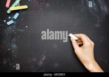 Weibliche Hand schreiben auf einer Tafel der Tischplatte mit weißer Kreide Stockfoto