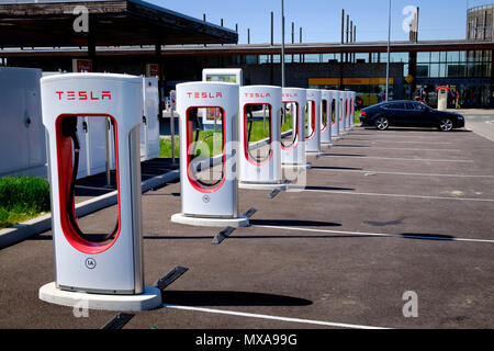 Tesla mit mehreren Ladestationen für Elektroautos an französische Service station Stockfoto