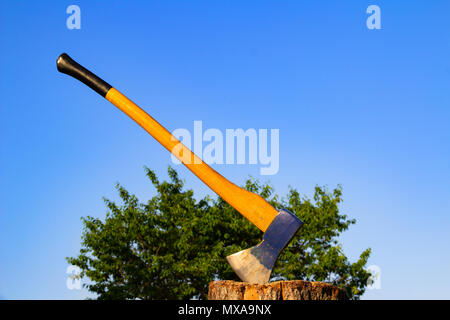 Ax gehaftet in einem Stamm. Blau ax hautnah. Holz arbeiten Konzept. Blau Ax Stockfoto