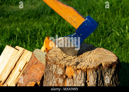 Ax gehaftet in einem Stamm. Blau ax hautnah. Holz arbeiten Konzept. Blau Ax Stockfoto