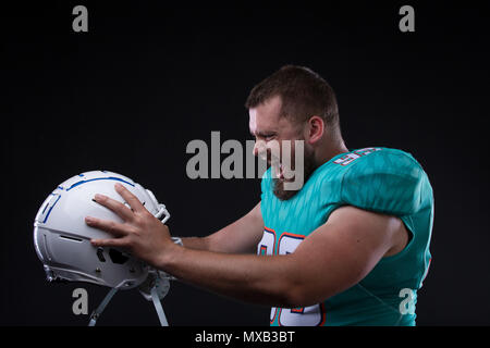 Sieg Agressive American football player am Helm zu schreien, während auf schwarzem Hintergrund stehen. Cpy Raum Stockfoto