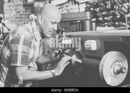 Professionelle reife Workman nachschärfen Messer interlock Spirale Rad system Maschine Stockfoto