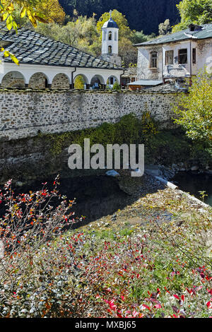 Tolle Aussicht auf die Kirche Mariä Himmelfahrt, Fluss und Herbst Baum in der Stadt von Shiroka Laka, Smoljan, Bulgarien Stockfoto