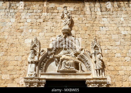 Kunstvolles design oben Eingangstür zum Franziskanerkloster auf Stradun in der Altstadt von Dubrovnik, Kroatien. Stockfoto